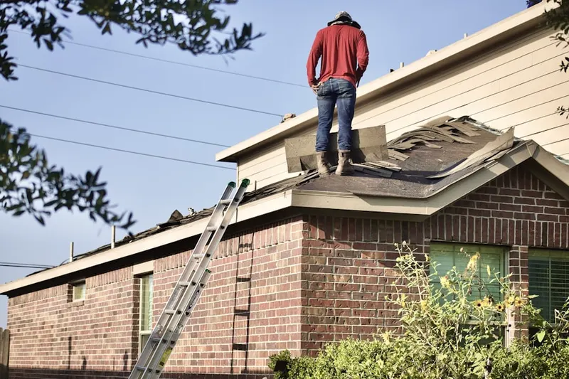 Professional roofer working on a residential roof in Chickasaw